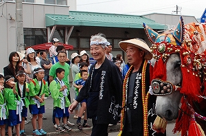 （写真＝馬コ行進に参加する高松さん）