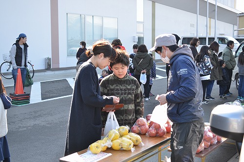 人々が野菜を購入している写真