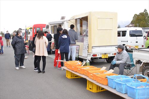 キッチンカーや屋台が立ち並び人々が買い物をしている様子