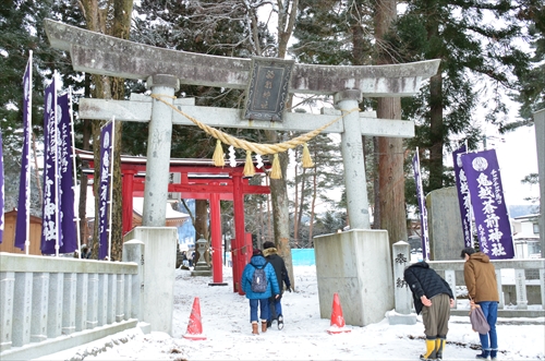 石製鳥居の下を人が歩いている様子