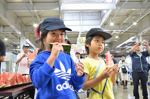 子どもたちがスイカに齧りついている様子