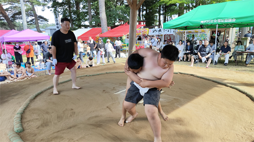 子どもたちが土俵の上で相撲を取っている様子