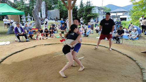 子どもたちが土俵の上で相撲を取っている様子