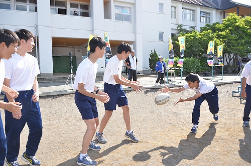 子どもたちがラグビーボールを投げ合っている様子