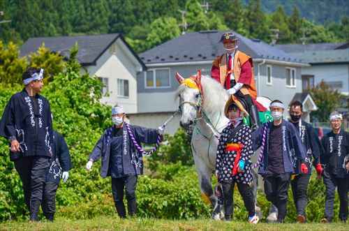 田んぼ沿いを馬が引かれていく様子