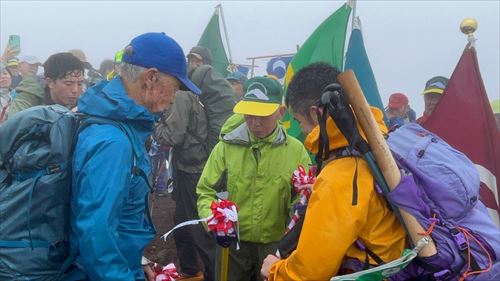 登山者が旗の前にいる様子