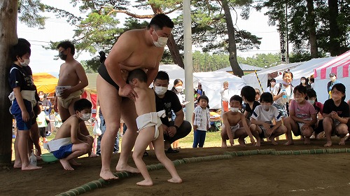 工藤良平さんと子供が相撲を取っている様子