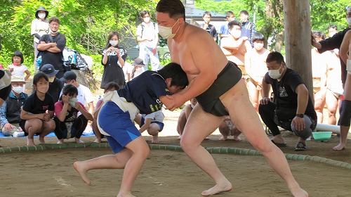 工藤良平さんと子供が相撲を取っている様子