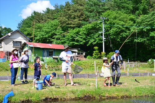 子どもたちがニジマス釣りをしている様子