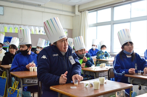 子どもたちが机に座り食べ物を食べている様子