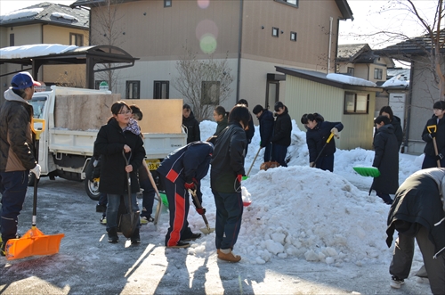 人々が雪寄せを行っている様子