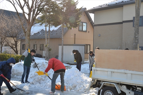 人々が雪寄せを行っている様子