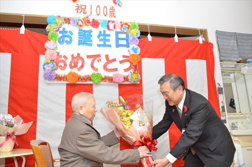 主濱市長から藤澤久五郎さんに花束を手渡ししている様子