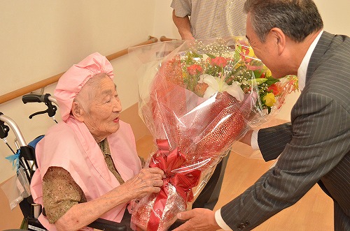 主濱市長が平原マサさんに花束を手渡ししている写真