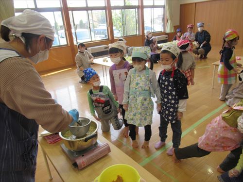 食べ物が作られているところを子どもたちが眺めている様子