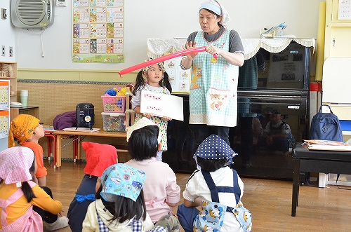 子どもたちが床に座り話を聞いている様子