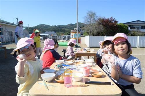 屋外で子どもたちが食事をしている様子