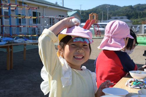 屋外で子どもたちが食事をしている様子