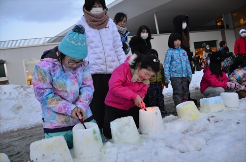 子どもたちが雪灯籠に火を灯す様子1