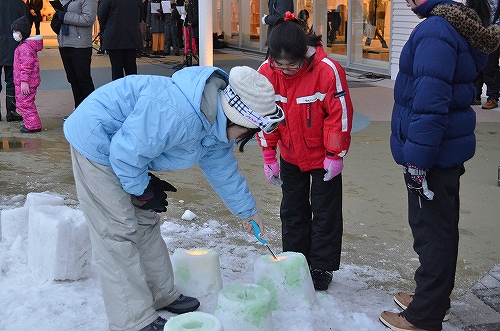 雪灯篭に火を灯す様子