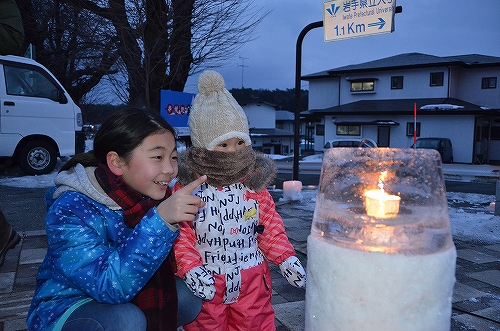 雪灯篭を見つめる子ども2人