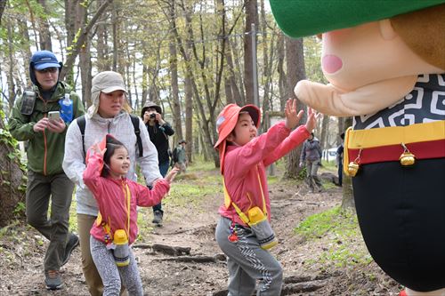 登山参加者とハイタッチをするちゃぐぽんの写真