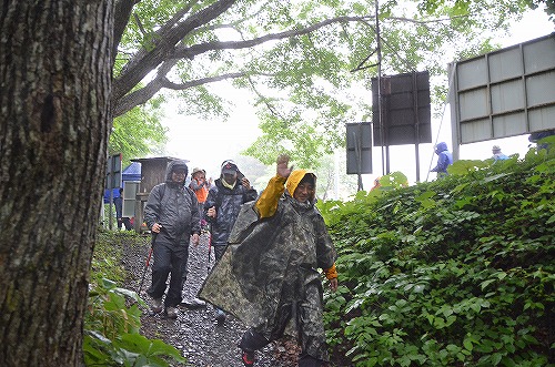 雨具を着込んで登山に向かう参加者