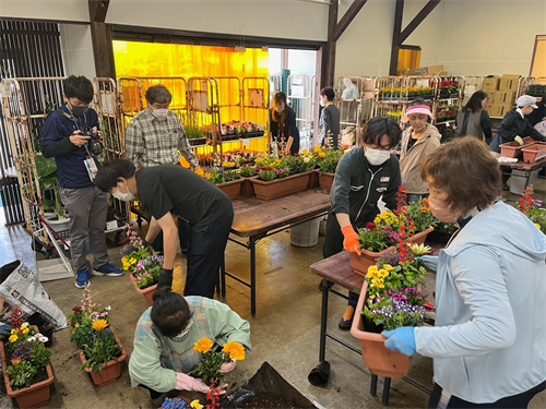 寄せ植えされたプランターを持ち運ぶみなさん