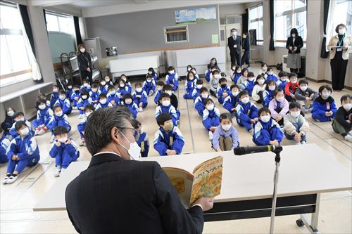 読み聞かせを行う武田市長と生徒たち（後ろからの写真）