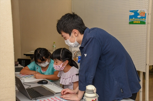 パソコンの画面を覗き込む女子児童