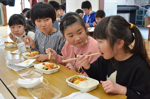 お弁当を頬張る女子児童