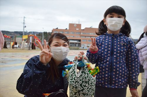 子どもと女性がピースをしている写真