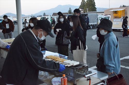 食べ物を焼いている様子を人々が眺めている様子