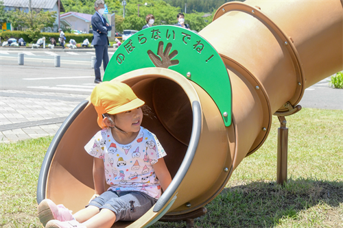 滑り台を滑った子どもの写真