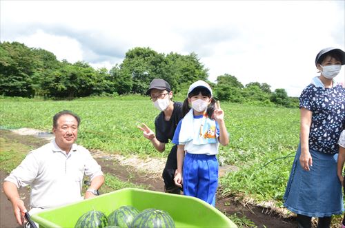 子どもたちと井上幸彦さんとスイカの写真