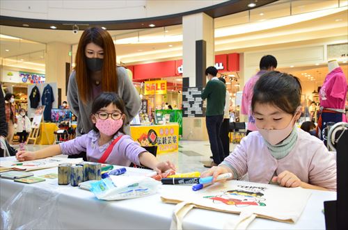 子どもたちがトートバッグ塗り絵をしている様子