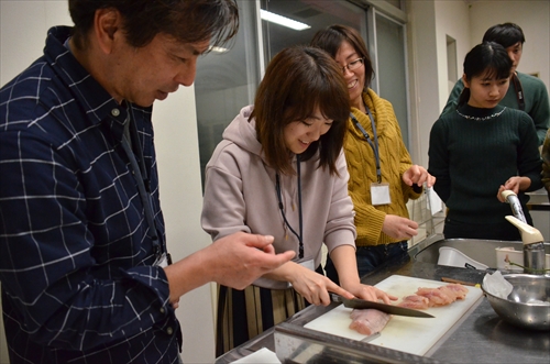 人々がイワナを捌いている様子