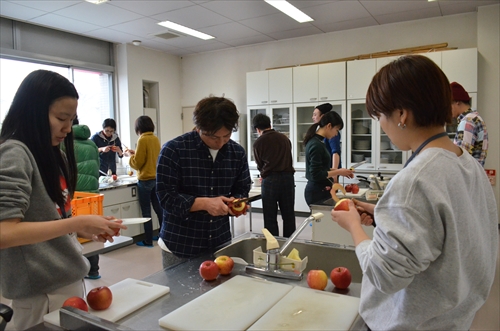 人々がりんごの皮を剥いている様子