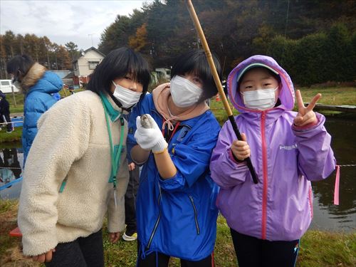 魚や釣り竿を手にもつ子どもたちの写真