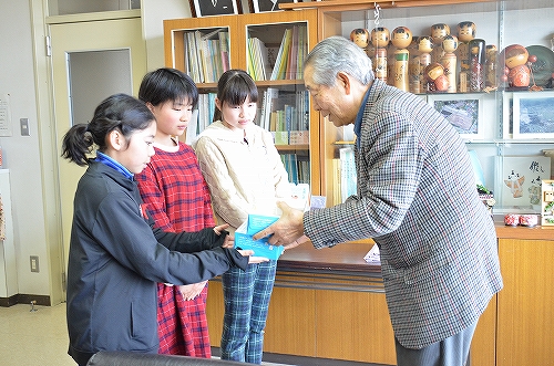 はがきを小学生から受け取る藤居宏一会長