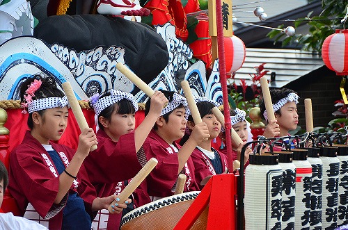 山車に乗り太鼓をたたく子供たちの様子