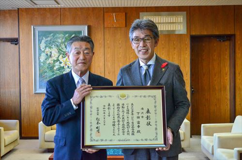 下田富幸さんと武田市長が表彰状を2人で持って写真に収まっている様子