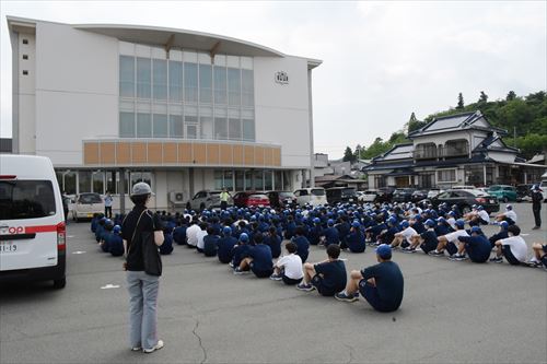 中学生がごみ拾い前に話を聞いている様子