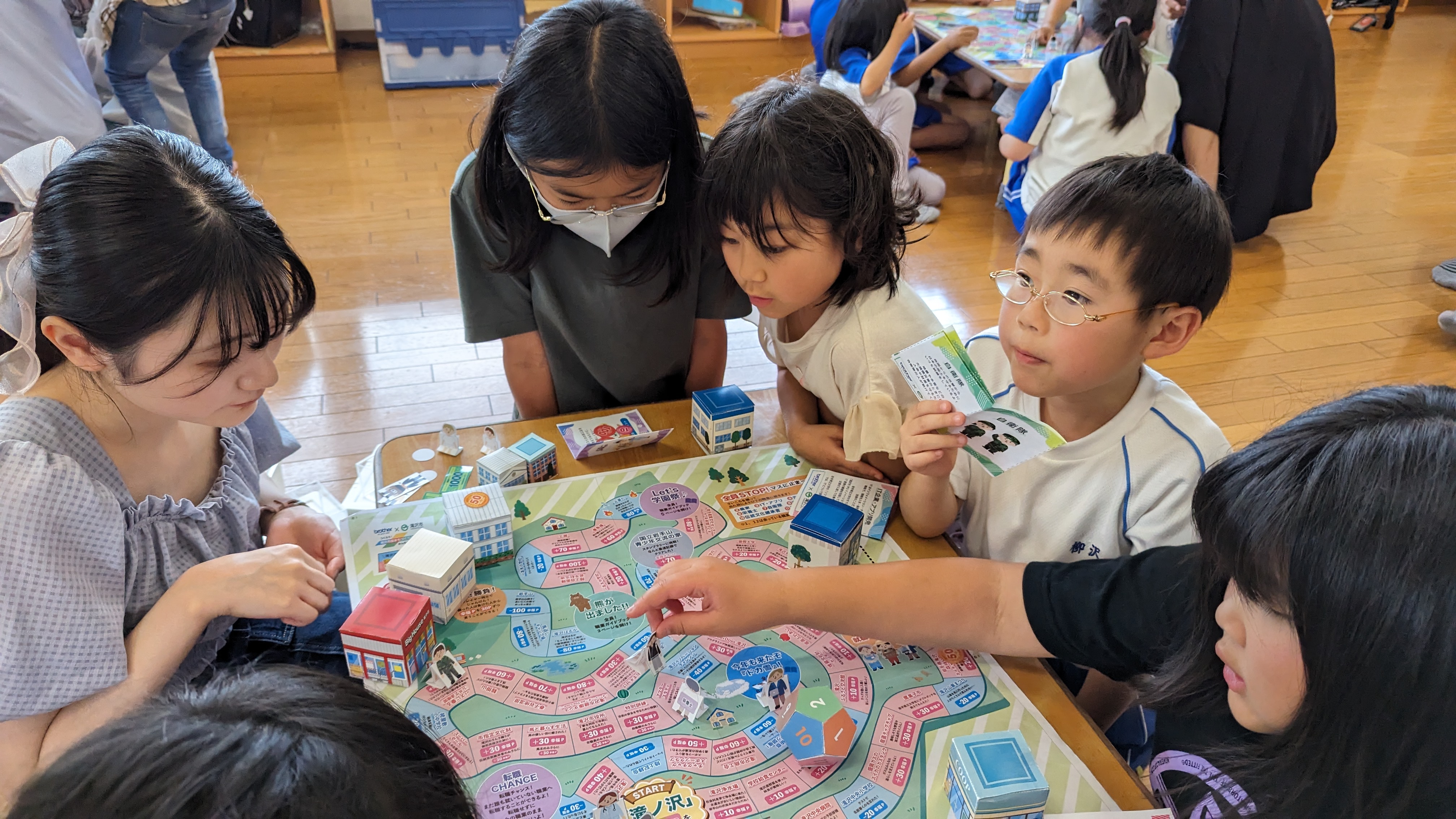 ひだまりキッズクラブ一本木で子どもたちがすごろくを遊んでいる様子