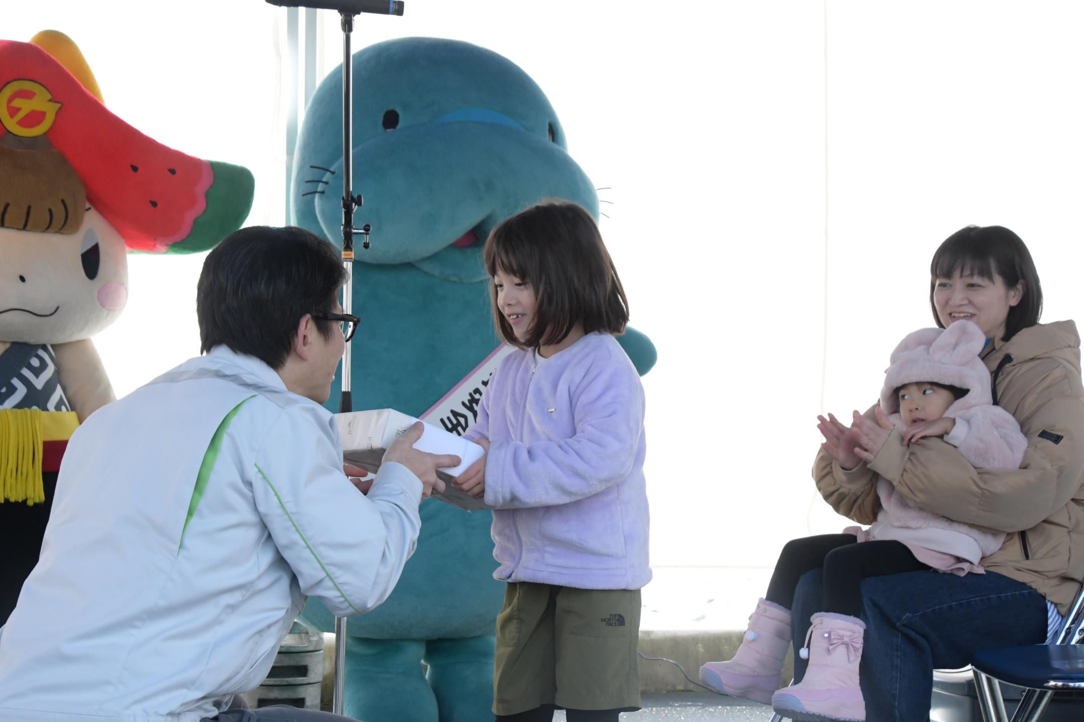 ネクスコ東日本盛岡管理事務所長から記念品を受け取るこうのさんの娘さん