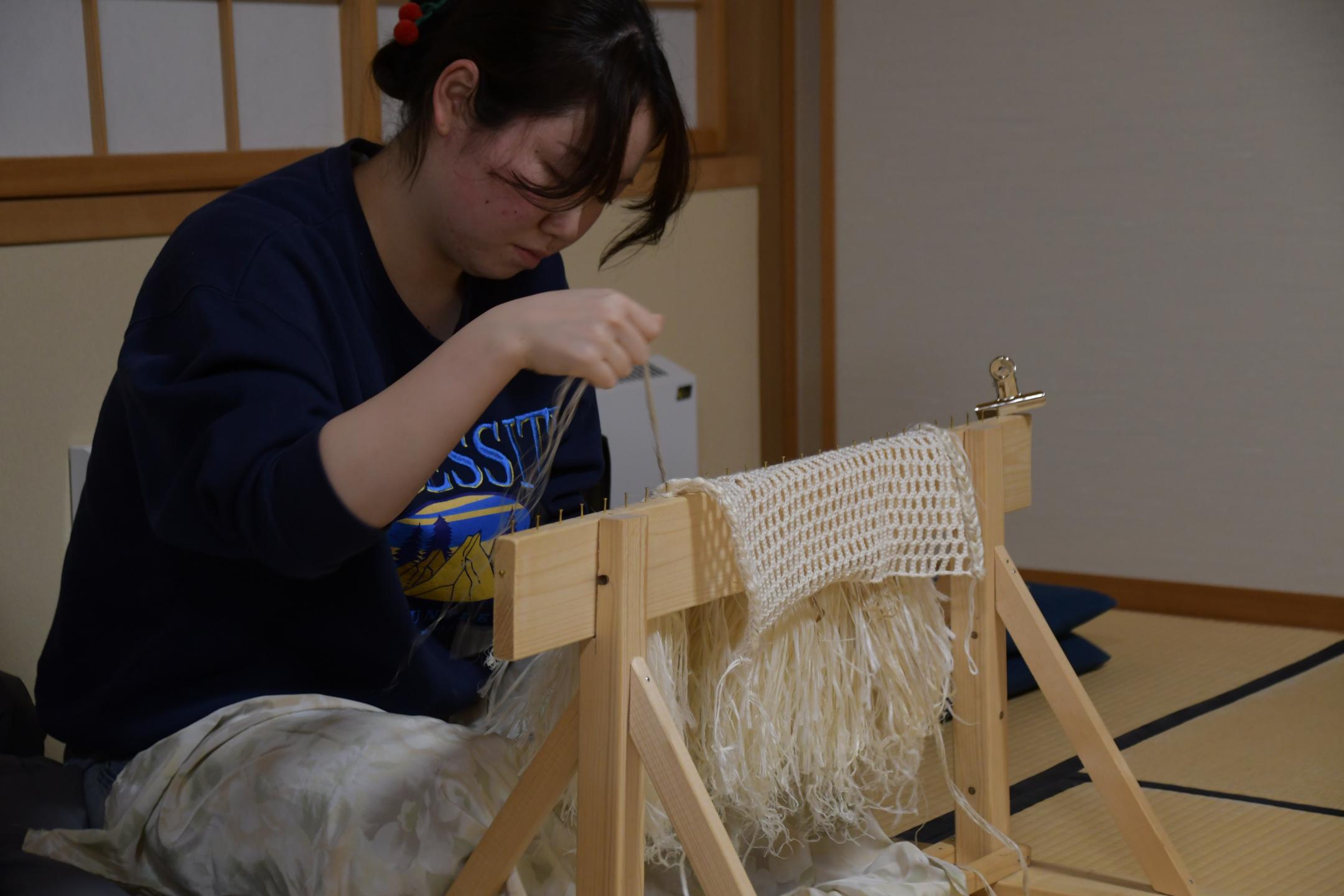 装束づくり講習会で馬コ装束を編む参加者